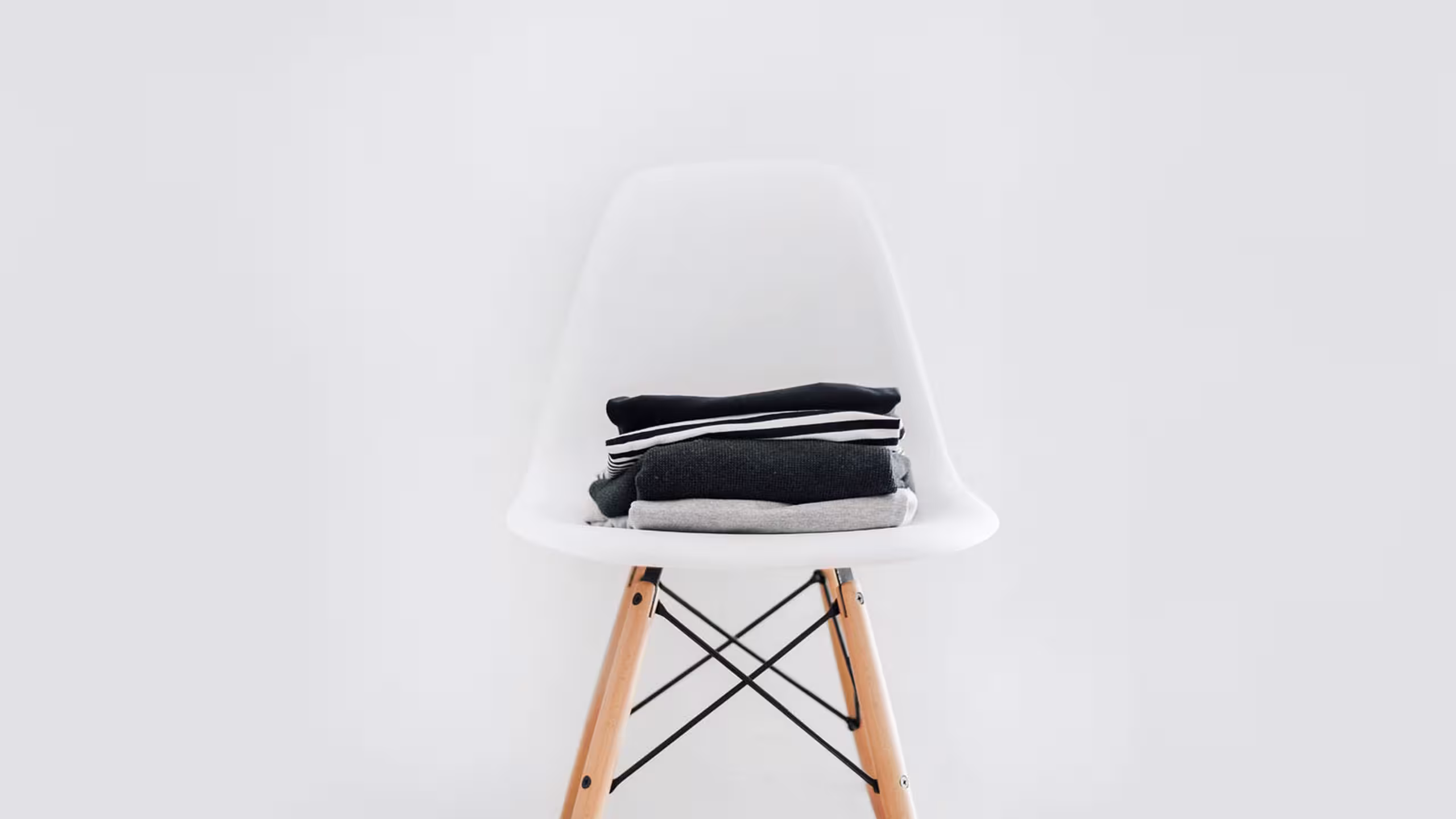 white chair with a small stack of folded shirts