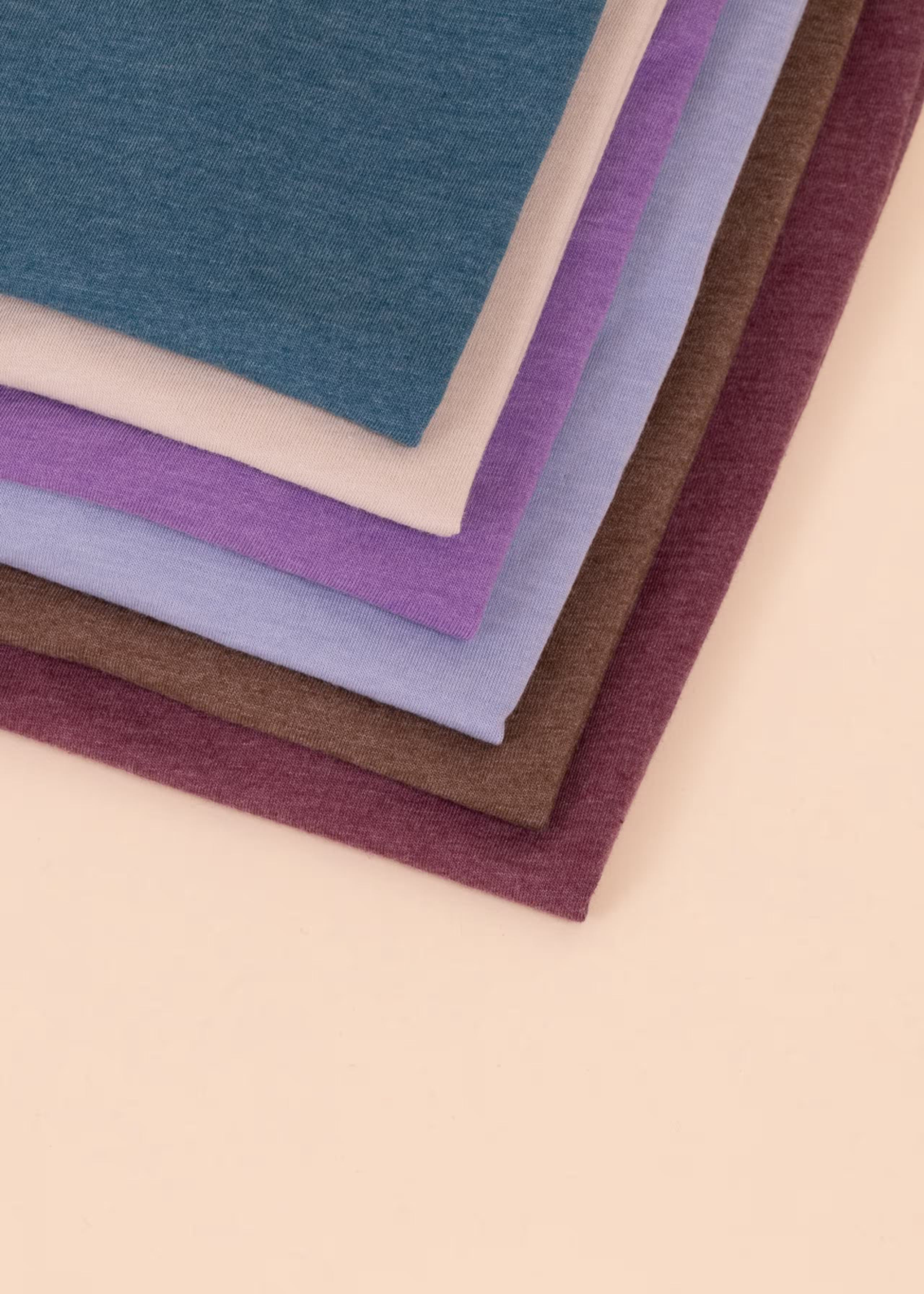 close-up of t-shirts folded on a tan background