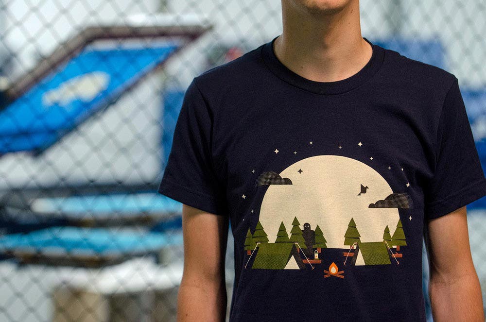 man wearing a black shirt with a scape of camping with a large moon man wearing a black shirt with a scape of camping with a large moon