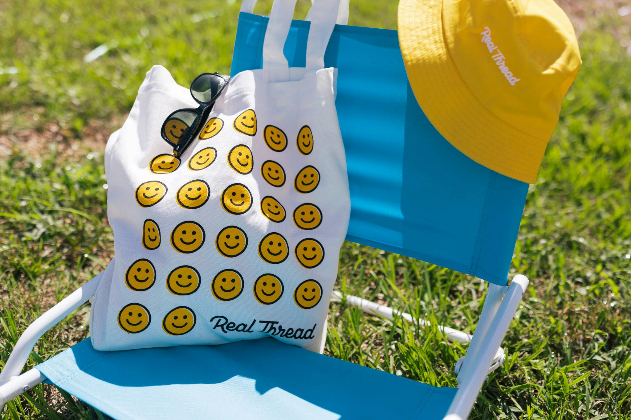 A beach chair with a custom tote bag and a custom beanie, both with fun pops of Real Thread yellow. A beach chair with a custom tote bag and a custom beanie, both with fun pops of Real Thread yellow.
