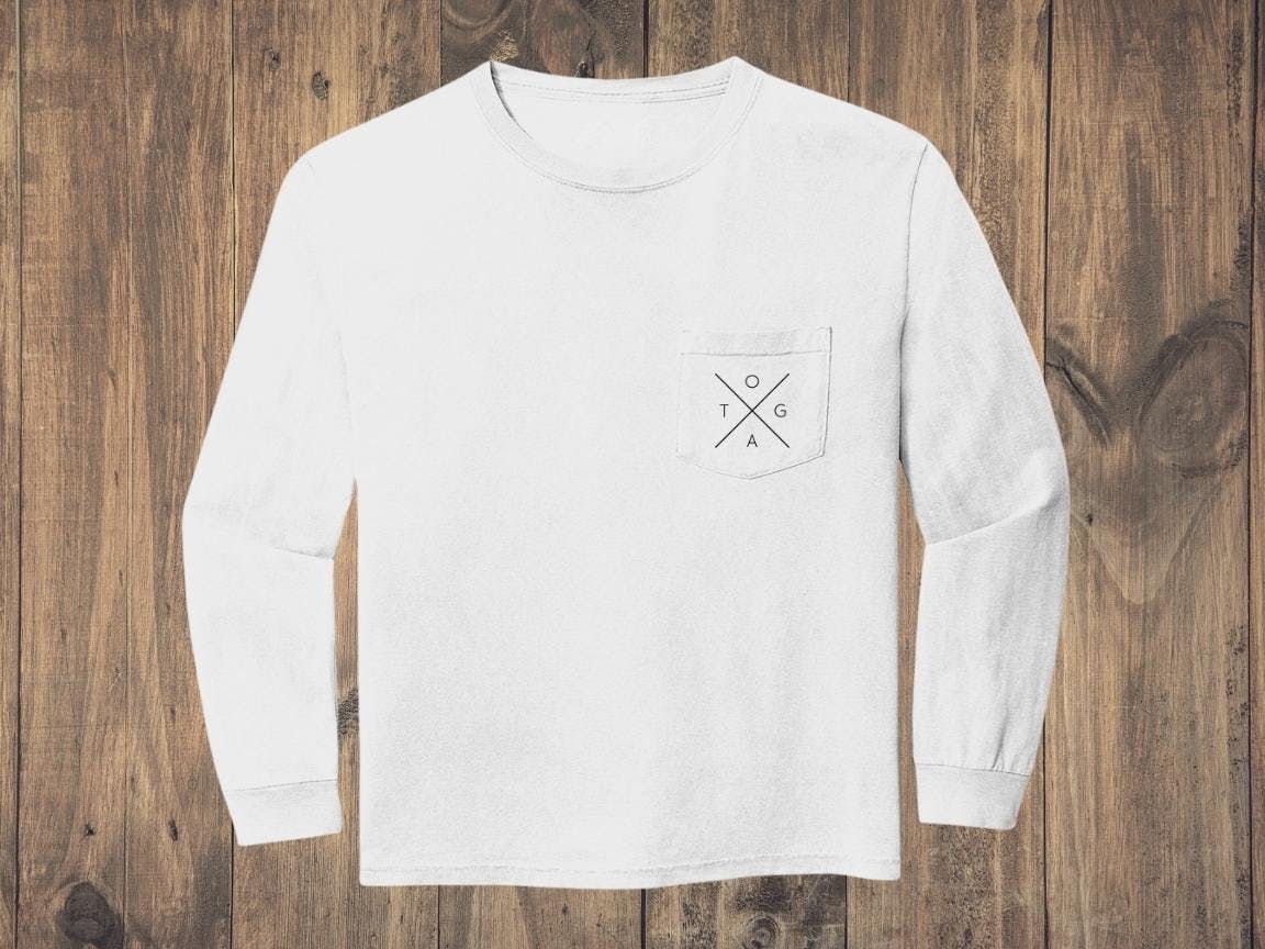 White sweatshirt with black X logo on front pocket against a wood background White sweatshirt with black X logo on front pocket against a wood background